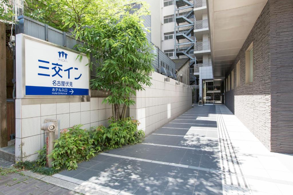 un callejón con una señal en el lateral de un edificio en Sanco Inn Nagoya Fushimi, en Nagoya