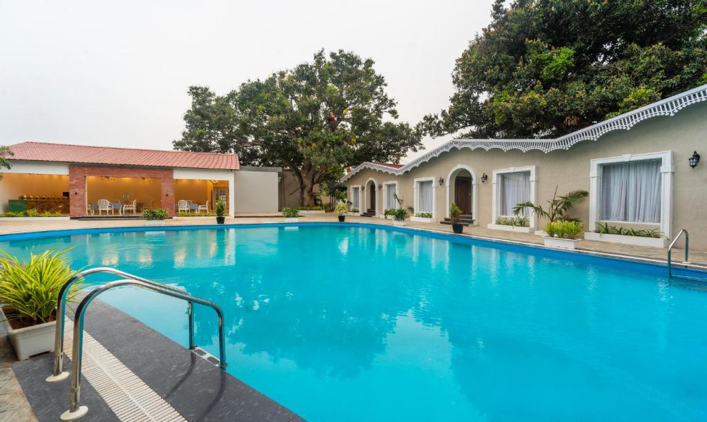 a large blue swimming pool next to a building at Treebo Trend Greenland Resort - Patia in Bhubaneshwar