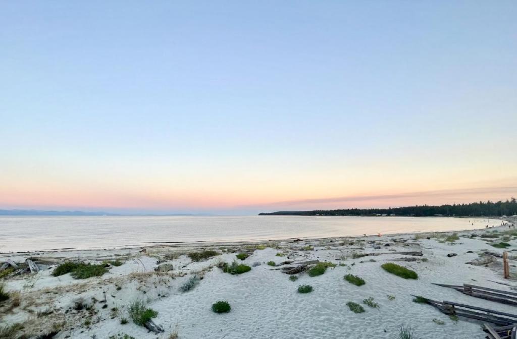 a beach at sunset with snow on the sand at Ocean View Town House #4 at THE BEACH HOUSE! in Campbell River