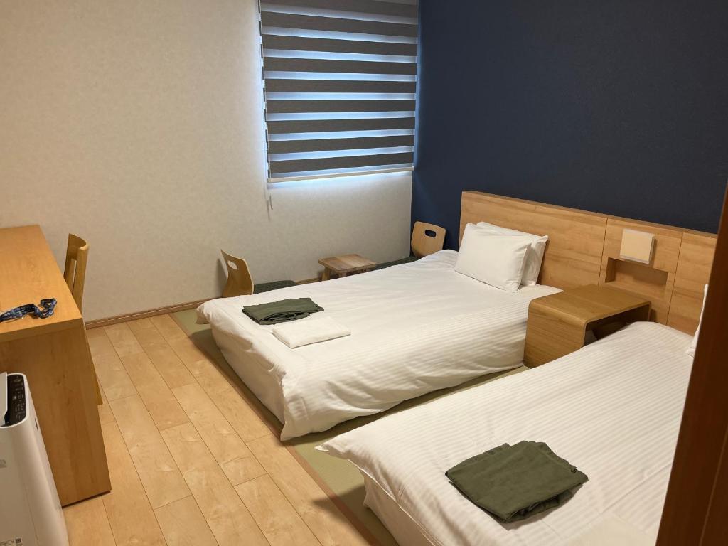 A bed or beds in a room at Business hotel ARM Futaba