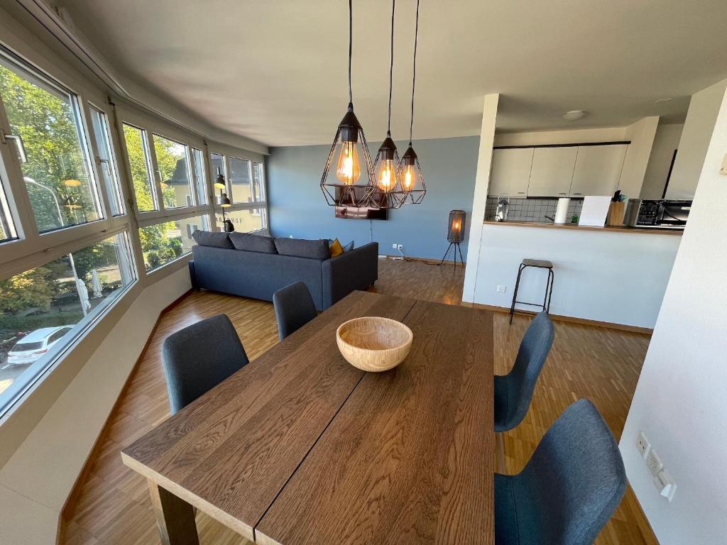 a dining room and living room with a table and chairs at ARISER - Zug Central Business Apartment in Zug
