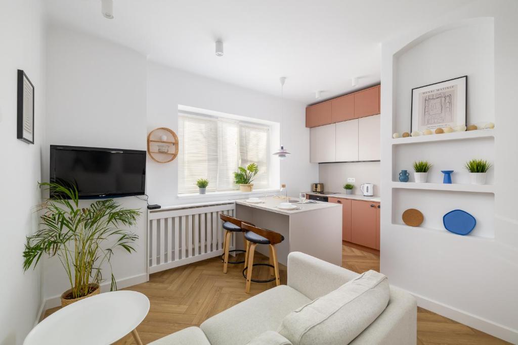 a kitchen and living room with a couch and a table at ECRU Design Apartment in City Center WWA46 in Warsaw