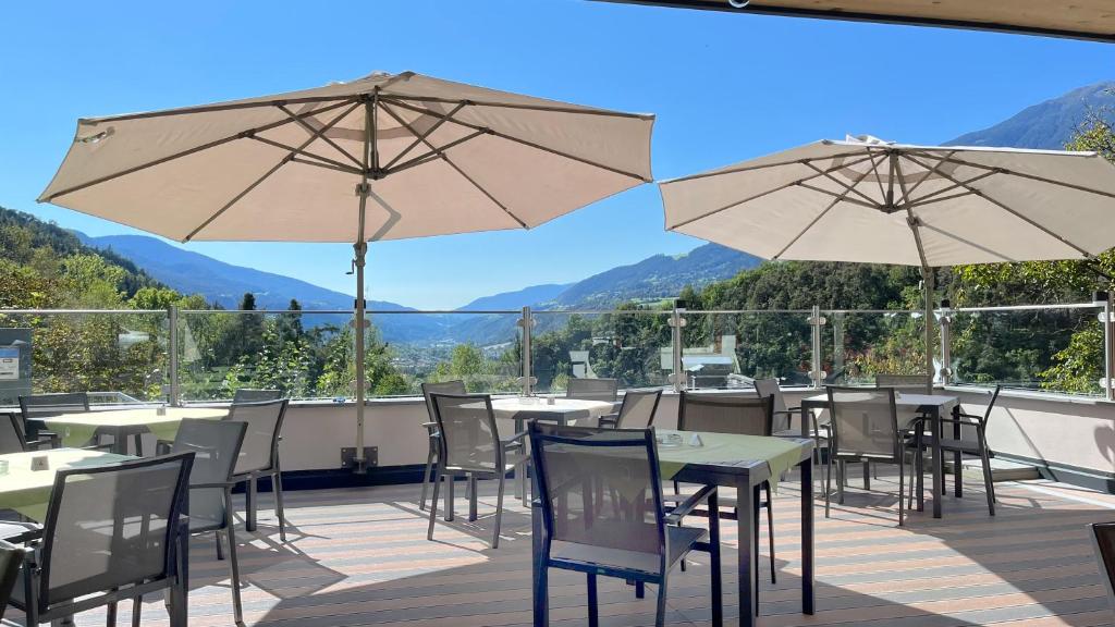 a patio with tables and chairs and umbrellas at Gasthof Majestic in Bressanone