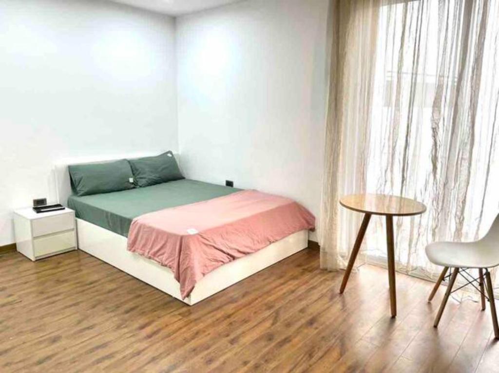 a bedroom with a bed and a table and a window at Cozy room close center 671 p41 in Hanoi