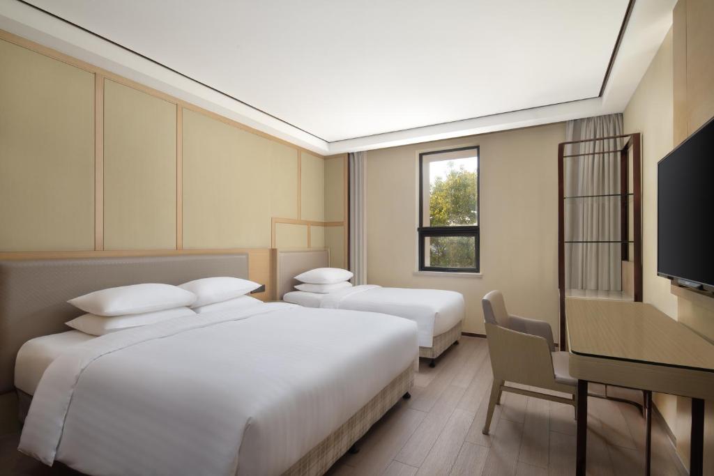 Postel nebo postele na pokoji v ubytování Courtyard by Marriott Shanghai International Tourism and Resorts Zone