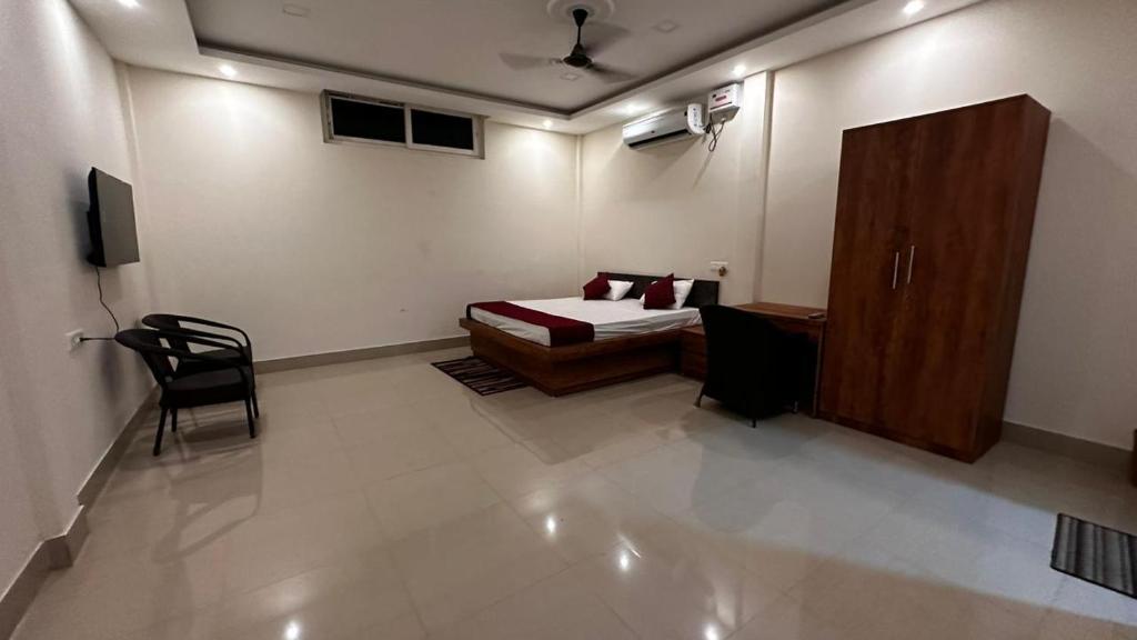 a bedroom with a bed and a cabinet and a chair at Long Acres in Guwahati