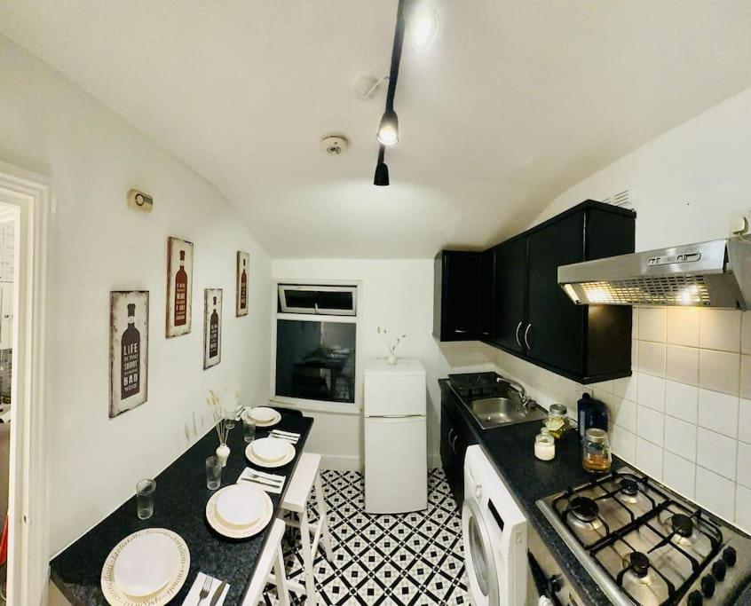 a kitchen with a black and white tile floor at *Super central 20min to Big Ben* in London