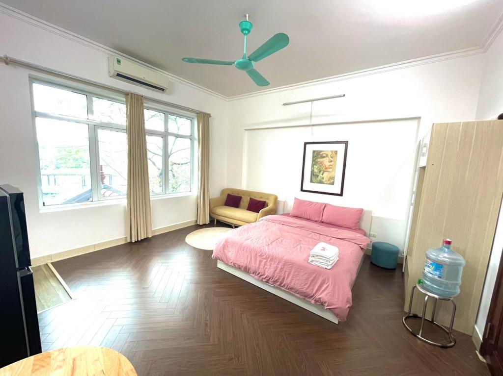 een slaapkamer met een roze bed en een plafondventilator bij Chill studio close Ho Tay ! (13-3.1) in Hanoi