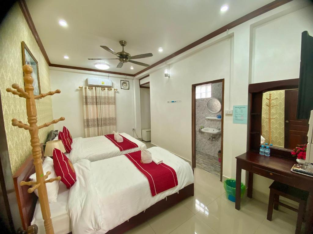 a bedroom with a bed and a desk and a sink at Xuan Keo place house 2 in Luang Prabang