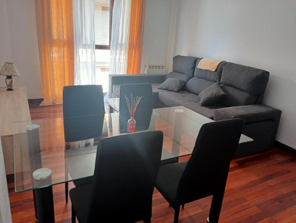 a living room with a glass table and a couch at Piso Loredo in Loredo