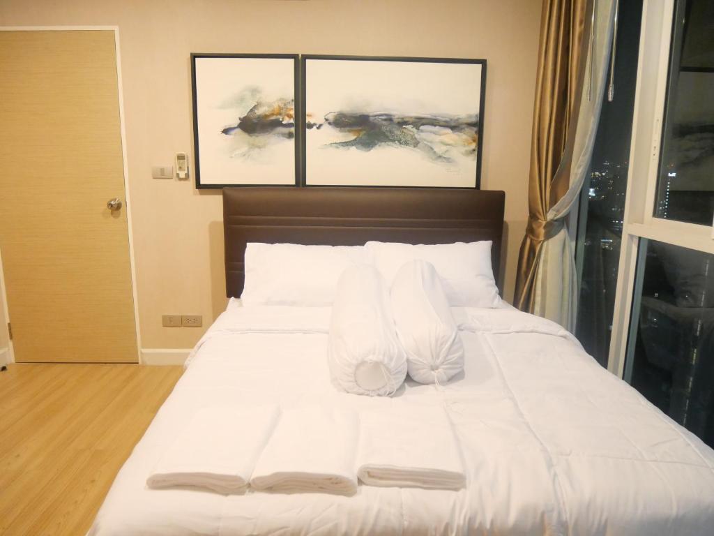 una camera da letto con un letto bianco e due dipinti di Rent-Saleคอนโดสุขุมวิท 2ห้องนอน 2ห้องน้ำ ใกล้ BTS อุดมสุข a Ban Khlong Samrong