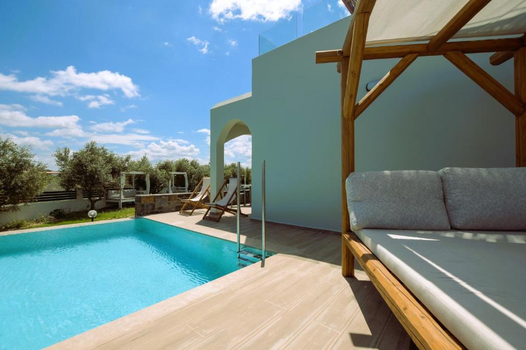 a house with a swimming pool and a couch at Malena Hotel & Suites - Adults Only by Omilos Hotels in Amoudara Herakliou