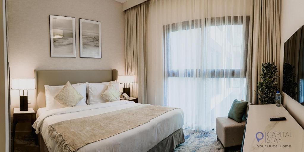 a bedroom with a large bed and a large window at Capital Stay - 2 Bed Apartment- The Address Fujairah in Fujairah