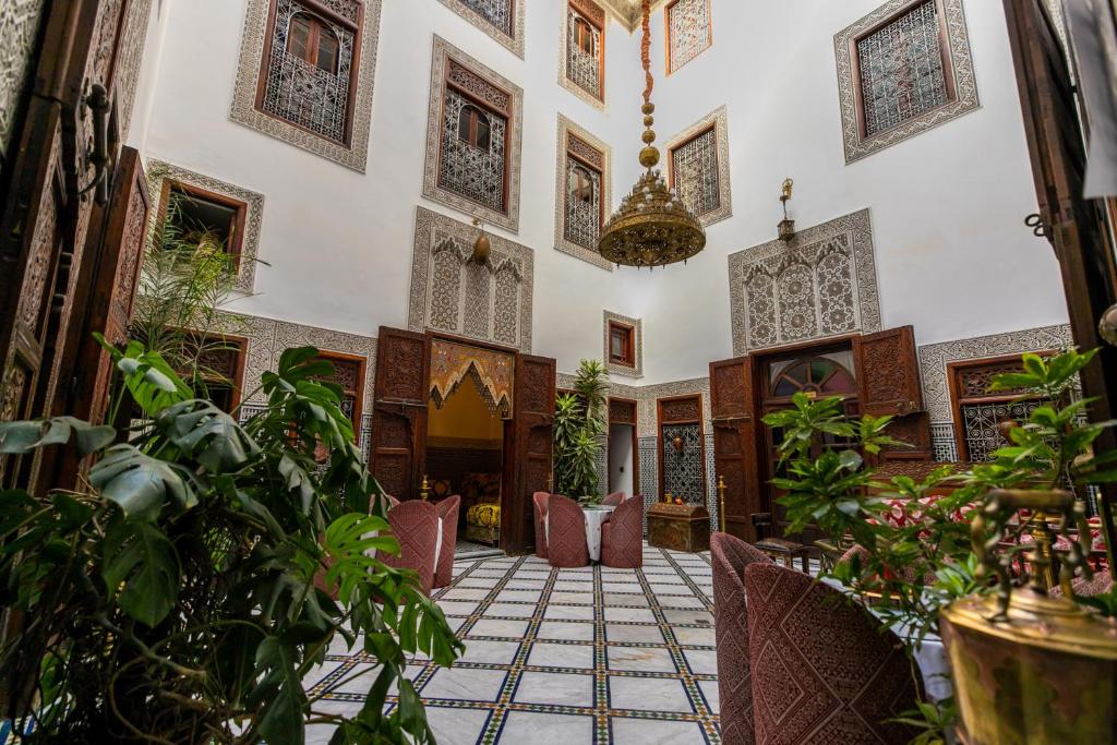 an ornate room with plants in a building at Riad Dar Chrifa - Luxury Escape in Fès