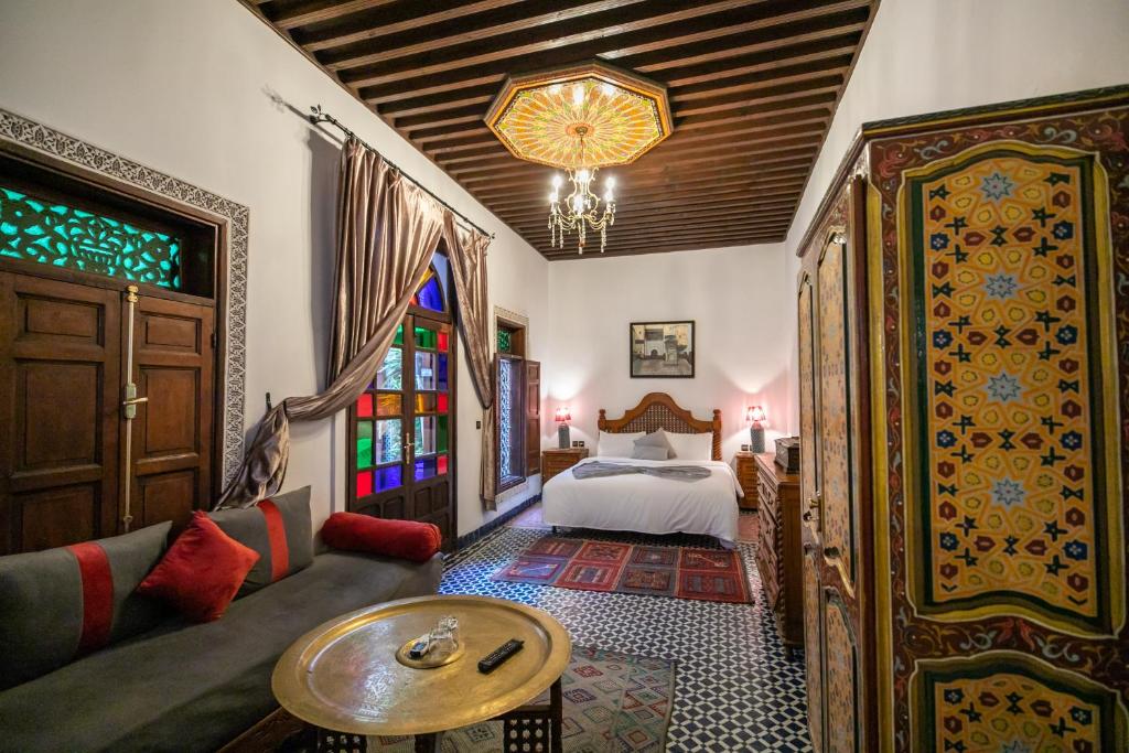 une chambre avec un lit, un canapé et une table dans l'établissement Riad Dar Chrifa - Luxury Escape, à Fès
