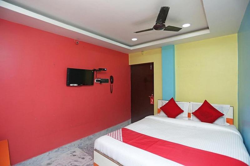 kolkataにあるHotel continentalの赤い壁のベッド1台が備わる客室です。