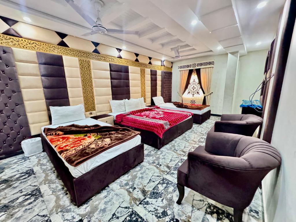ein Hotelzimmer mit 2 Betten und einem Stuhl in der Unterkunft Royal Blue inn Hotel in Islamabad