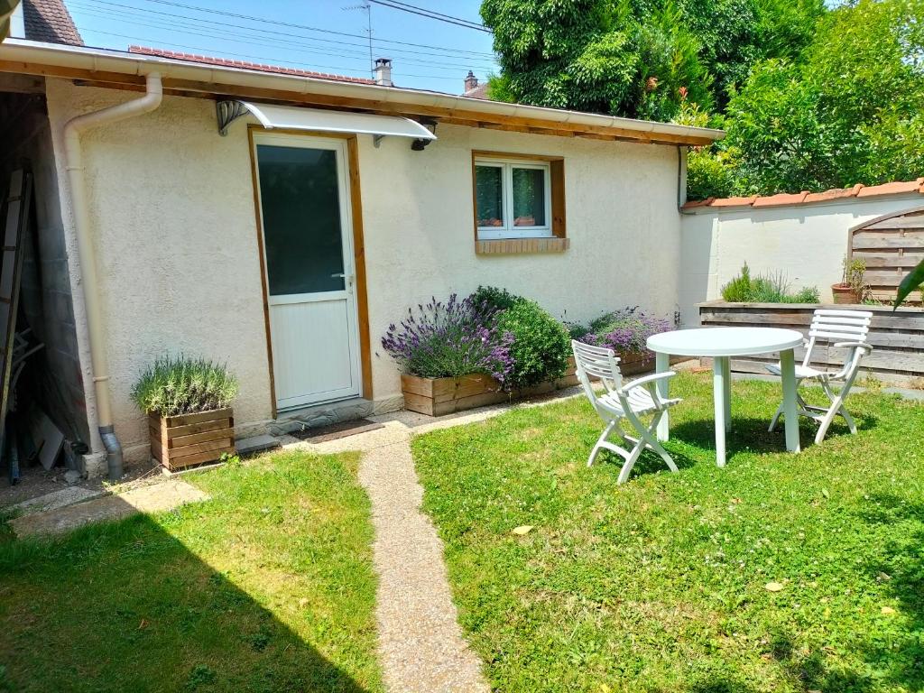 - une table et des chaises dans la cour d'une maison dans l'établissement Chelles-Max01, à Chelles
