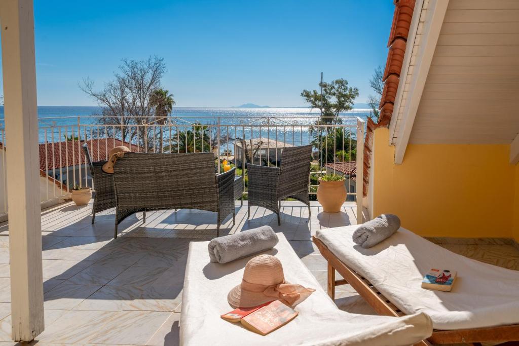 a balcony with a table and chairs and the ocean at Southbank seafront apartments in Katelios