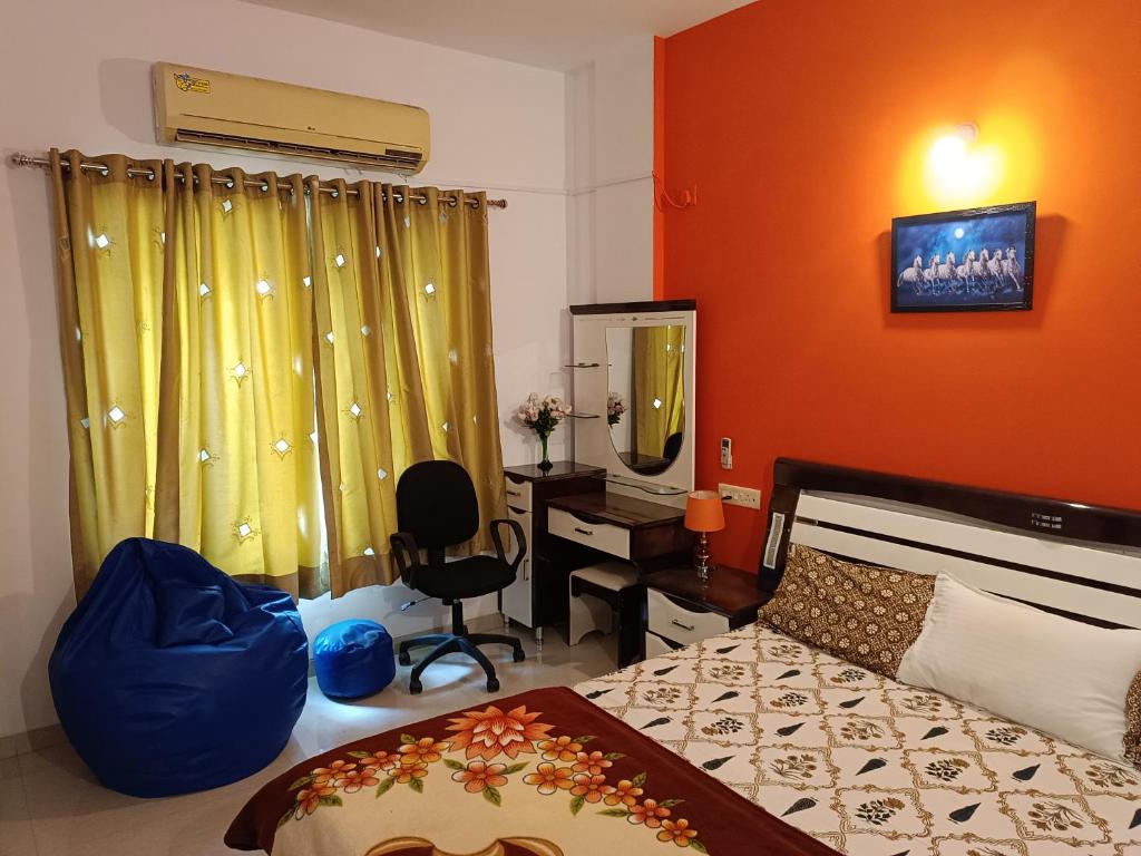 a bedroom with a bed and a desk and a television at Blue Diamond Guest House in Pune