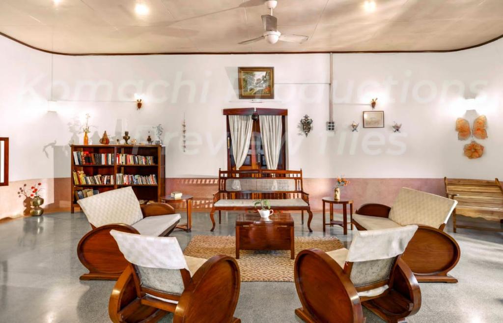 ein Wohnzimmer mit Stühlen und einem Tisch in der Unterkunft Dutch Square Hostel in Alappuzha