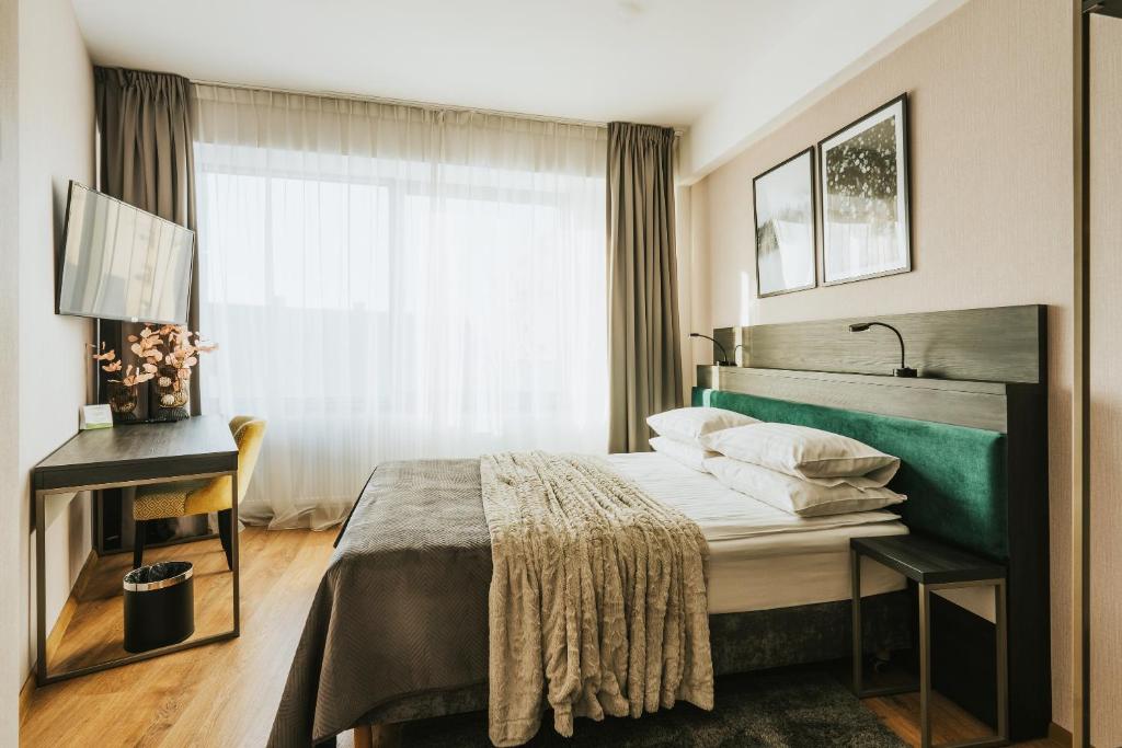 a hotel room with a bed and a window at Green Hotel in Inowrocław