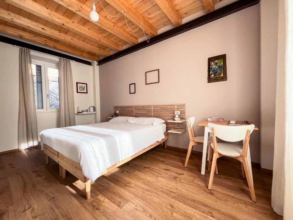 RIAREL- Foresteria Lombarda في Rodero: غرفة نوم بسرير وطاولة وكراسي