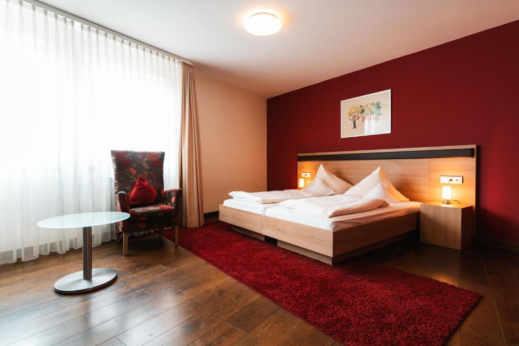 1 dormitorio con cama y pared roja en Landhotel und Weingasthof Schwarzer Adler, en Wiesenbronn