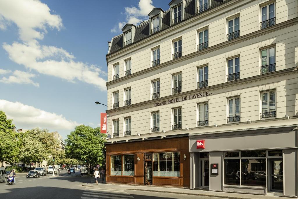 - un grand bâtiment blanc dans une rue de la ville dans l'établissement ibis Paris Avenue de la Republique, à Paris