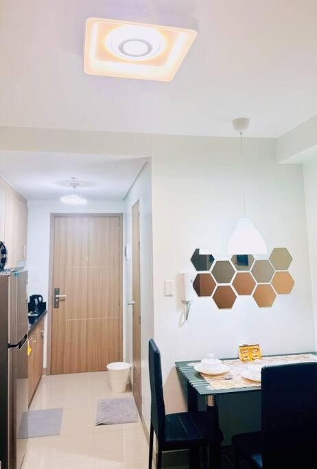 a kitchen with a table and a room with a toilet at Shabby Chic & Contemporary Condo in Manila