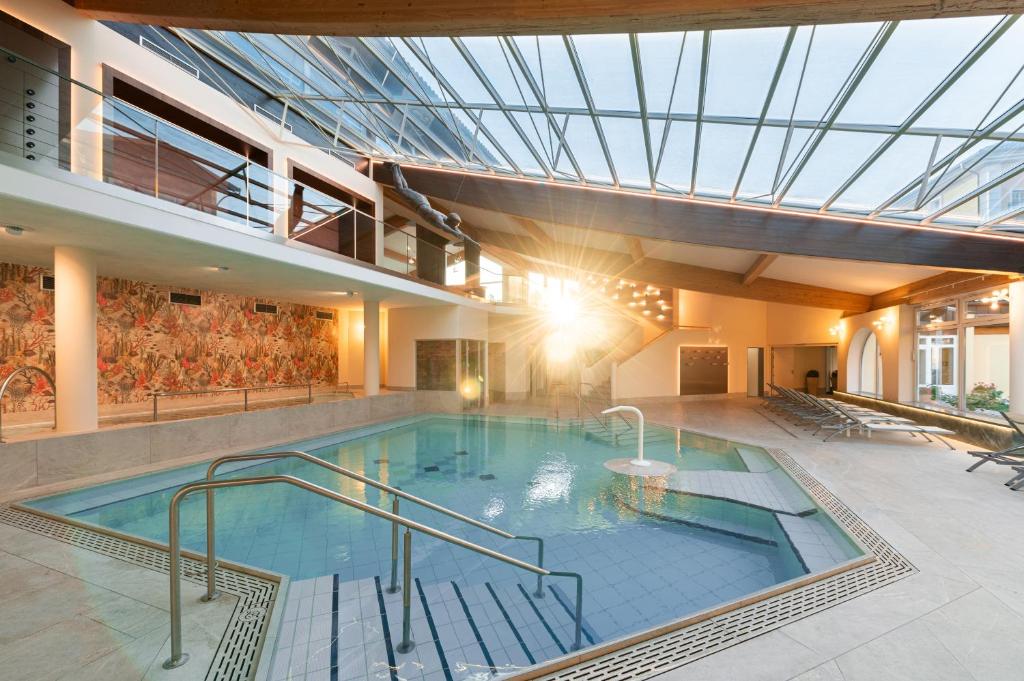 a swimming pool in a building with a glass ceiling at Kurhotel Zink e. K. in Bad Füssing