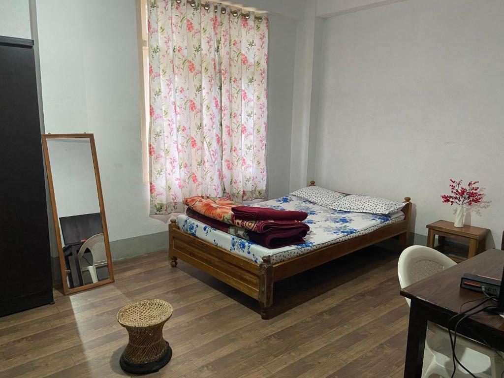 a bedroom with a bed with a window and a mirror at Maple Homestay in Kohīma