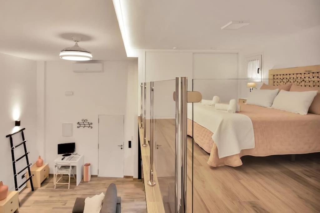 1 dormitorio con 1 cama grande y sala de estar en Moderno loft en el corazón histórico de Estepona - CASA PEPITA 17, en Estepona