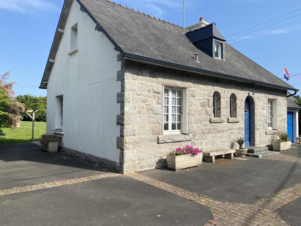un petit bâtiment en briques avec un banc devant lui dans l'établissement 755 -Maison en pierre à Erquy proche de la plage, à Erquy