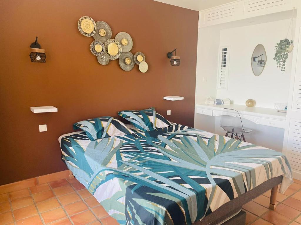 Schlafzimmer mit einem Bett und Wandplatten in der Unterkunft TI BONHEUR DE TARTANE in La Trinité