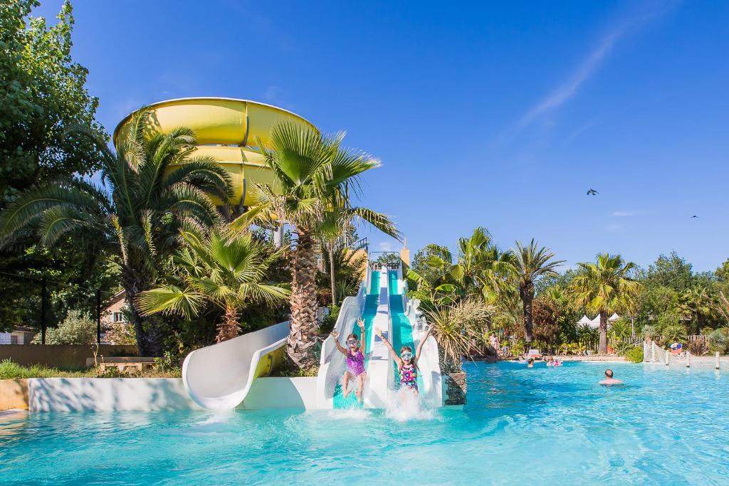 eine Wasserrutsche in einem Pool in einem Resort in der Unterkunft Camping l&#39;Etoile de Mer - Maeva in Sérignan