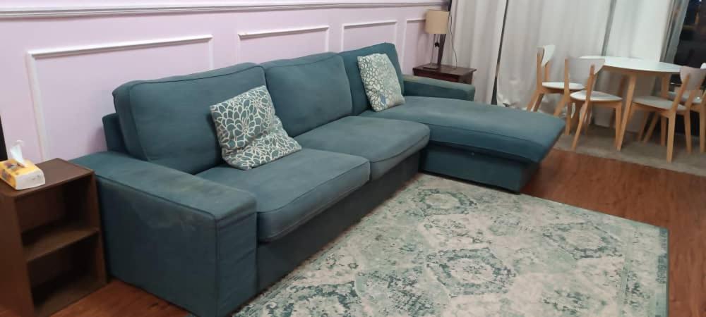 um sofá azul numa sala de estar com um tapete em The Elements @ Ampang em Kuala Lumpur