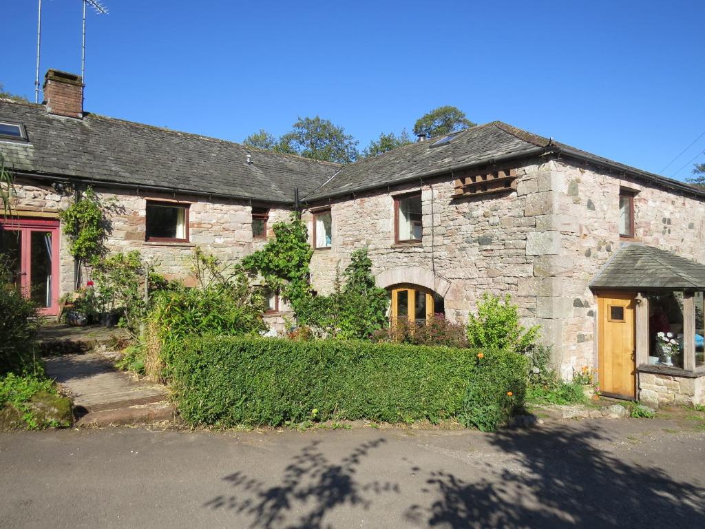 an old stone house with a red door at Sockbridge Mill Bed and Breakfast in Penrith