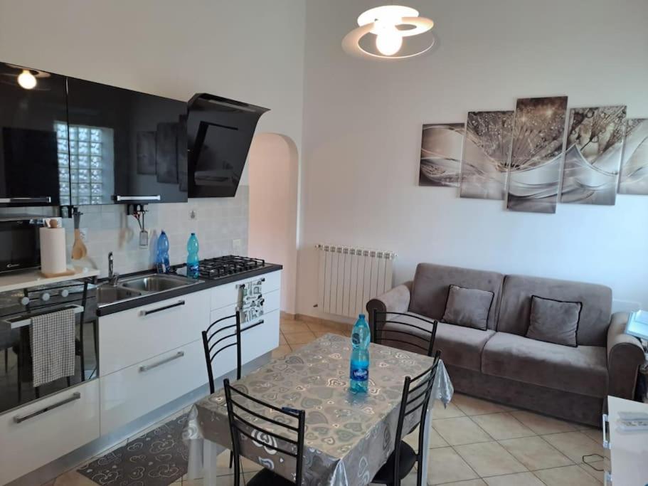uma cozinha e sala de estar com uma mesa e um sofá em account non operativo prenotare su residenze villa claudia grazie em Anzio