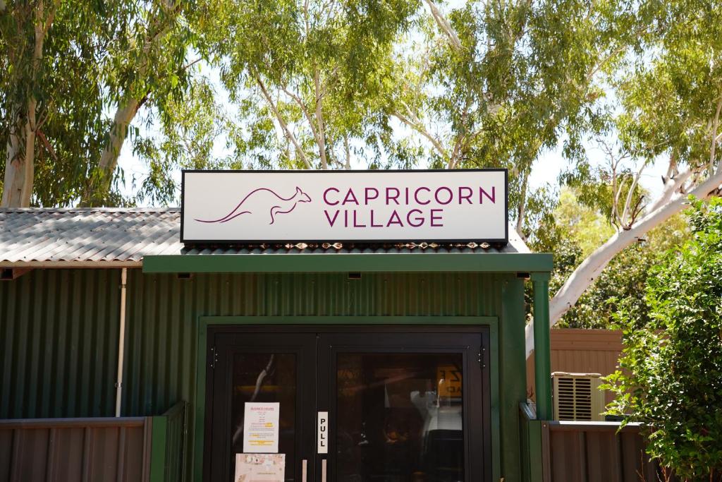 um sinal para uma aldeia carleton no topo de um edifício em Capricorn Village em Newman