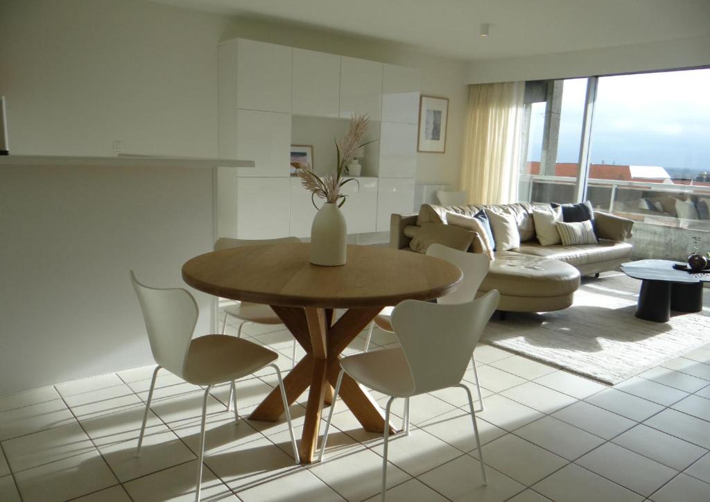 sala de estar con mesa y sillas en Boek nu je verblijf - Perfecte locatie om tot rust te komen met zonneterras!, en Nieuwpoort