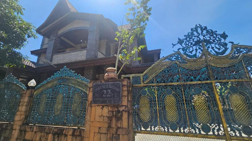 a building with a fence with a sign on it at CASA ALRAWDAH in Kampung Padang Masirat