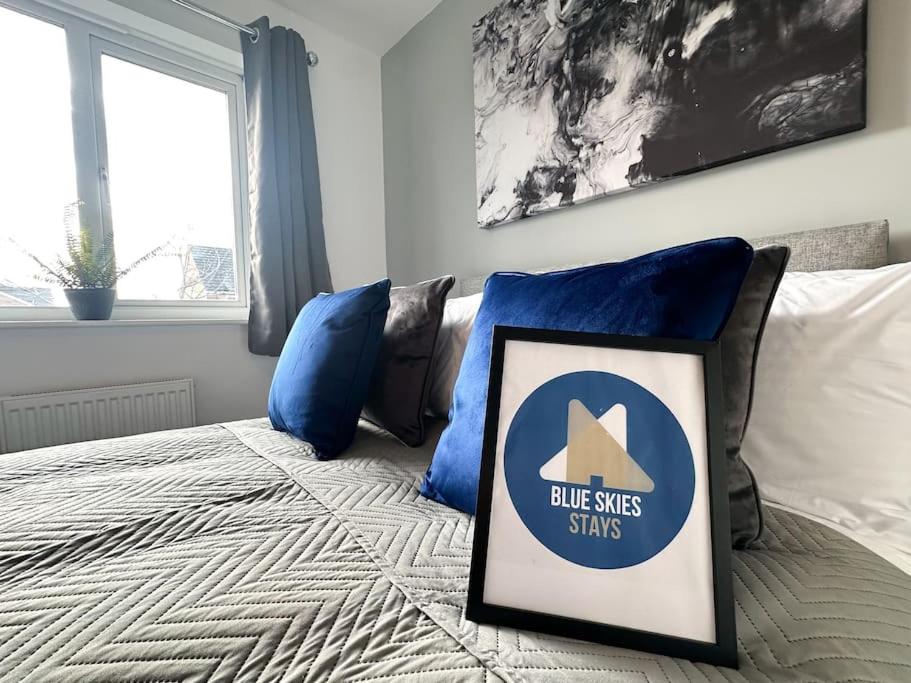 a bed with a blue pillows and a sign on it at No.32 by Blue Skies Stays in Bowburn