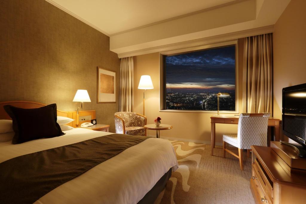 a hotel room with a bed and a large window at Hotel Nikko Kanazawa in Kanazawa