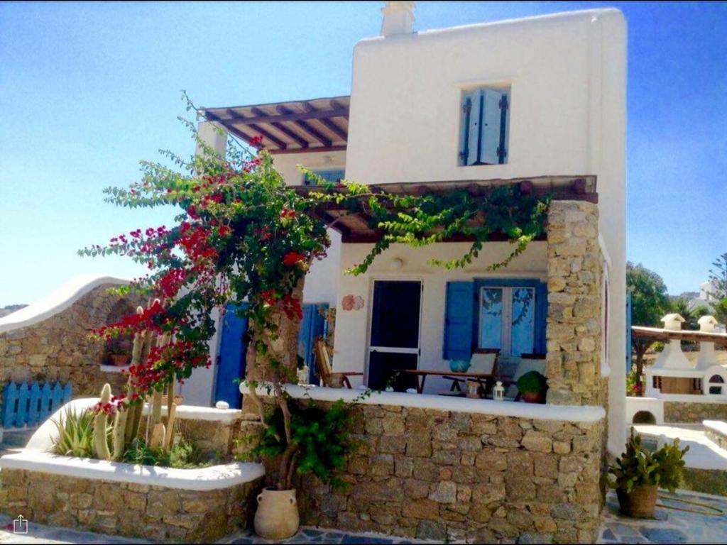 a small house with flowers in front of it at Beautiful Traditional Apt in Ano Mera Mikonos in Ano Mera