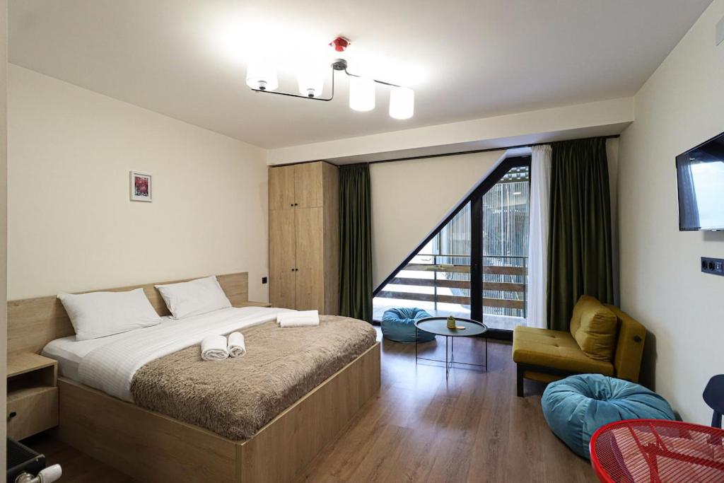 ein Schlafzimmer mit einem Bett und einem großen Fenster in der Unterkunft Marshall Gudauri Stylish Apartment By Wehost in Gudauri