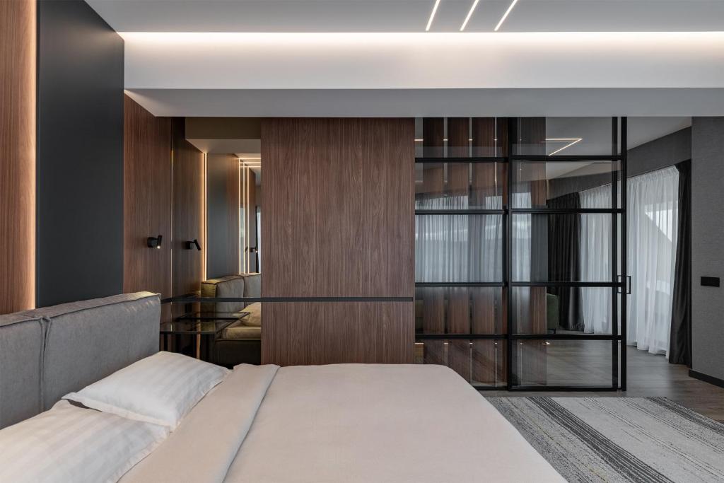 a bedroom with a bed and a glass wall at Boudoir Apartment City Tower - 15th floor in Cluj-Napoca