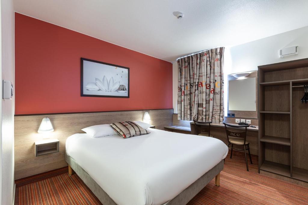 Creutzwald-la-CroixにあるAce Hotel Creutzwald Saint Avoldのベッドとデスクが備わるホテルルームです。