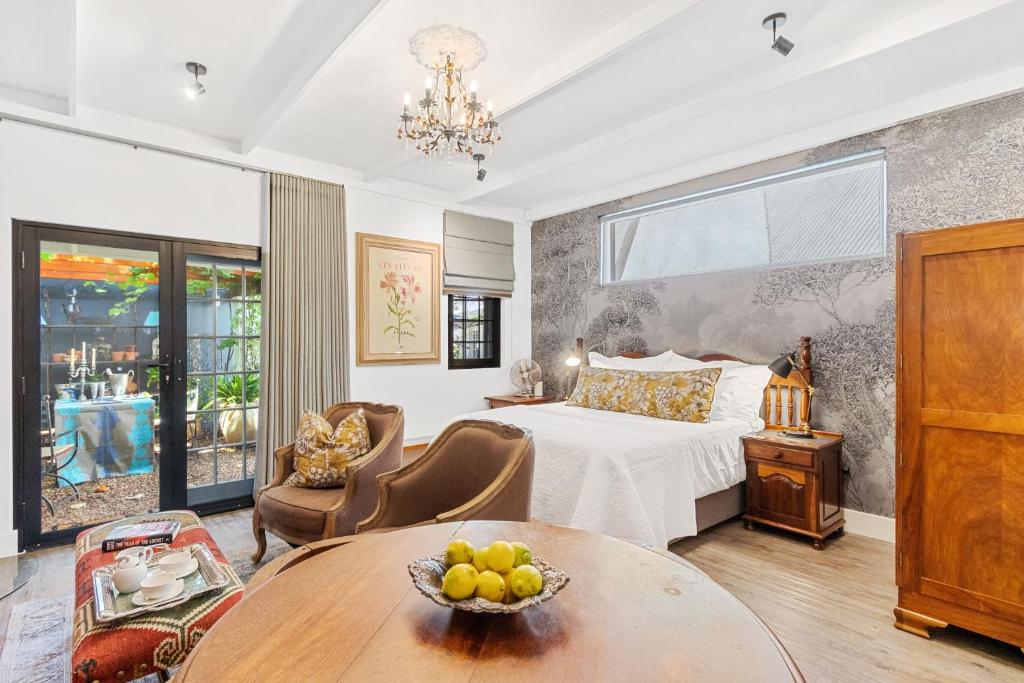 a hotel room with a bed and a table at Maison Dandelion in Franschhoek