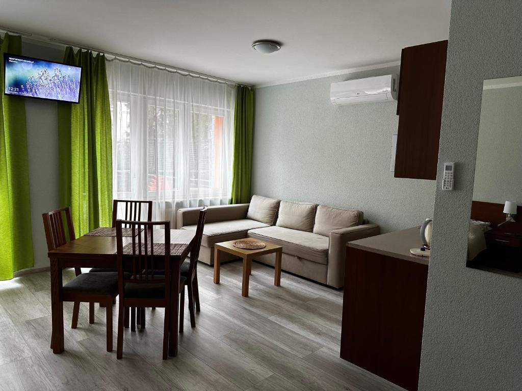 sala de estar con mesa y sofá en Kompleks Apartament-Serwis, en Cracovia
